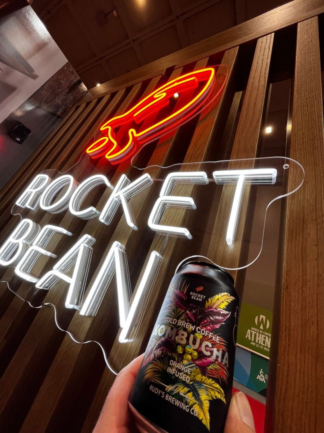 Vit och röd LED-neonskylt med kafélogotyp bakom baren